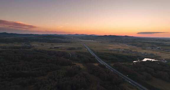 航拍夕阳下穿过草原的高速公路