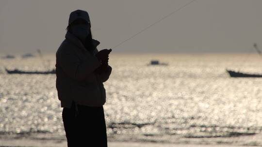 海边放风筝的女子与渔船