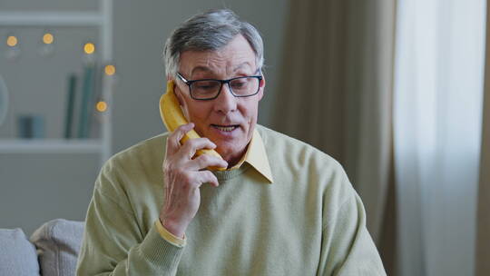 爷爷拿着香蕉假装在打电话