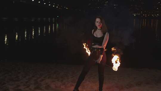 女性杂耍演员从沙子中举起燃烧的火炬