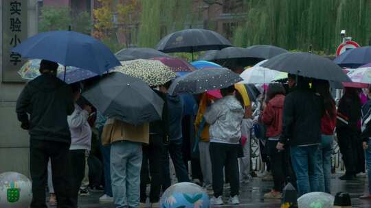 学校门口阴雨家长接孩子放学