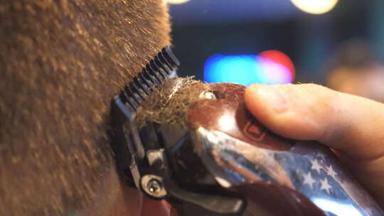 发型师用电动剃须刀剪头发的特写