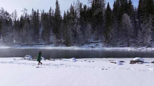 航拍新疆阿勒泰冬季喀纳斯游客在雪地上游玩