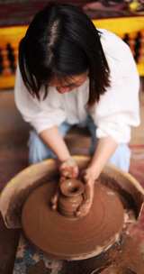（慢镜）年轻女子在制作土陶陶瓷制作
