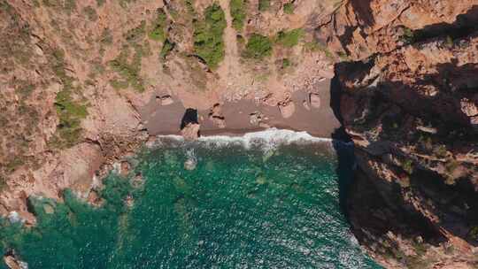 红沙海滩海浪压碎海滩的空中俯视图