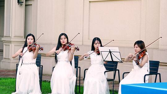 4K升格实拍四名草坪上演奏小提琴的女孩