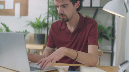 在办公室用笔记本电脑工作的年轻商人视频素材模板下载