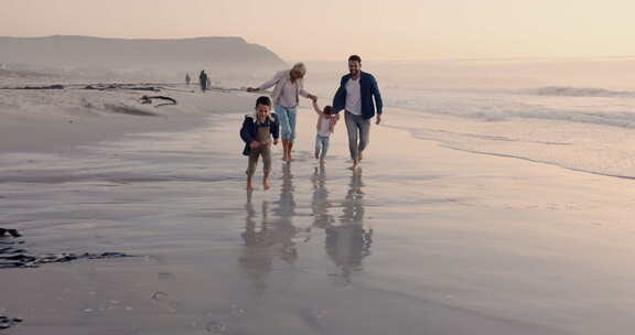 父母，孩子和手牵着手跑步，海滩或户外在日