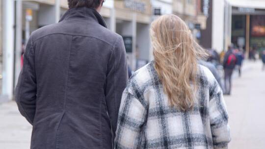年轻情侣在城市街道散步