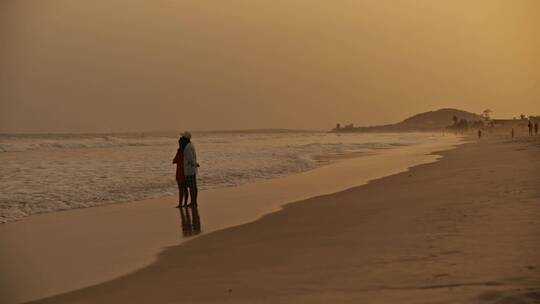 黄昏情侣在海滩上看日落