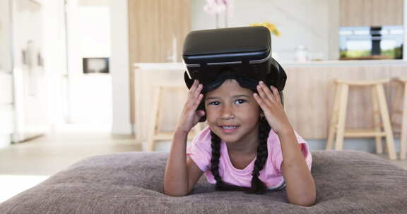 戴着VR耳机的出生女孩在现代客厅微笑