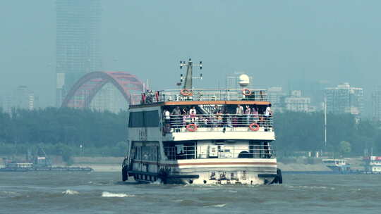 武汉江面上的渡轮红色晴川桥城市大楼背景