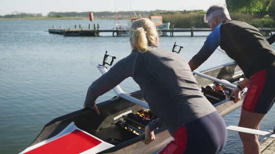 男女组成的划艇队将船放入河中视频素材模板下载