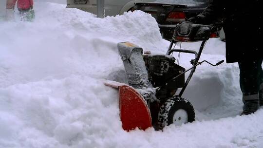 一名男子用吹雪机清除积雪