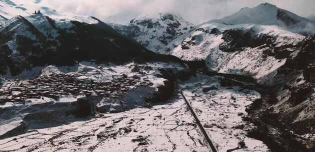 白雪覆盖的山脉和村庄的无人机镜头