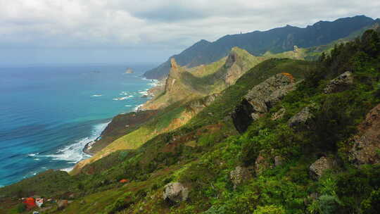 春天绿色的山峰与海洋清澈的绿松石水背景