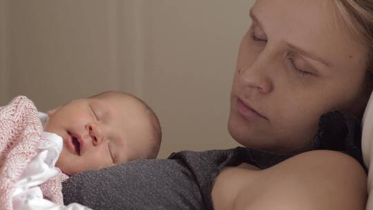 女人抱着熟睡的婴儿视频素材模板下载
