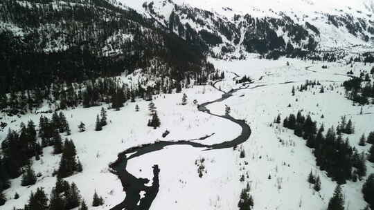 无人机在白雪皑皑的阿拉斯加山区的一条小河