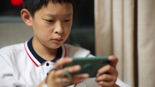 男孩在手机上玩游戏视频素材模板下载