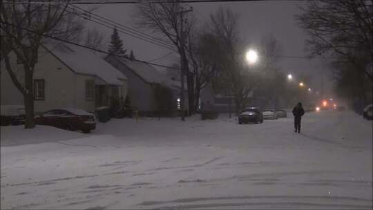 冬夜行人漫步积雪街道