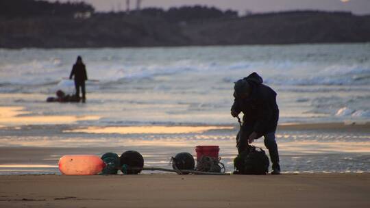 黄昏时分海边沙滩上赶海的老渔民