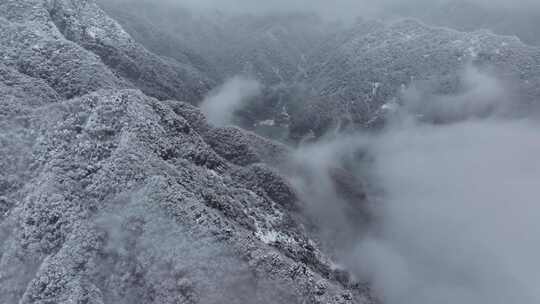 雪覆山峦云雾缭绕景象