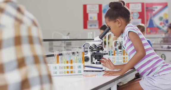 女孩在上课时用显微镜