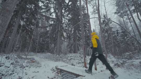 男人在冬天的森林雪地行走