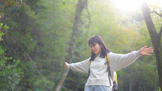 年轻活力女孩户外踏青张开双臂小溪石墩行走