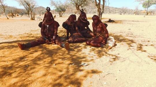 辛巴部落妇女坐在荒野沙漠上
