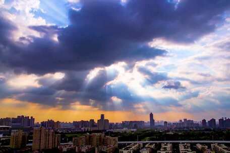 城市上空阳光穿透云层的壮观景象