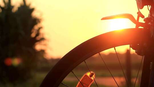 ​夕阳黄昏照射自行车车轮变焦光点自行车