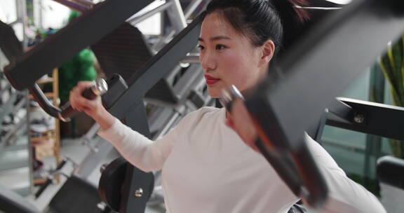 美女健身房锻炼身体适应器械练力量训练