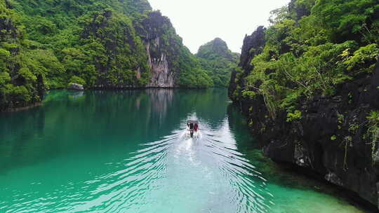 空中跟随拍摄的旅游快艇在蓝色泻湖的巴拉望菲律宾