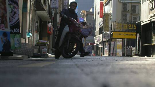 首尔骑轻便摩托车的人