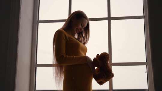 孕妇抱着泰迪熊和谐深情快乐女性未来母亲享