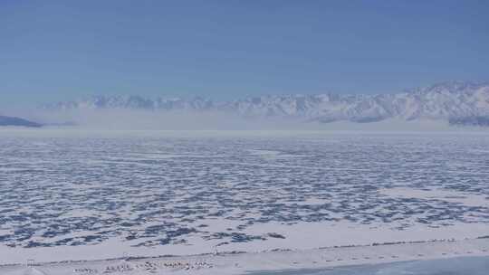 航拍新疆冬季赛里木湖冰封湖面雪山冰湖雪景