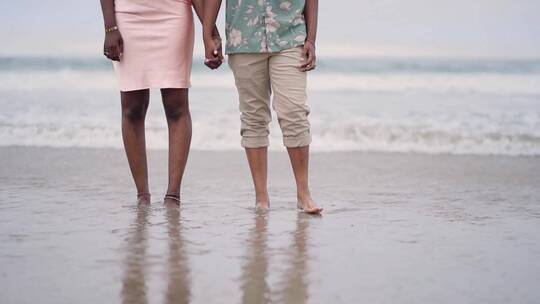 手牵手在海滩上散步的夫妇