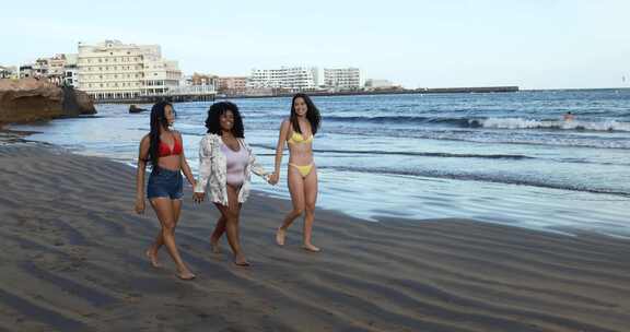 快乐的多种族女性与不同的身体和皮肤有乐趣在夏天的一天在海滩上