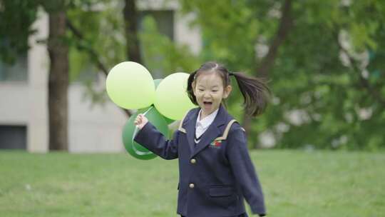 穿校服女孩手持气球在草地上奔跑