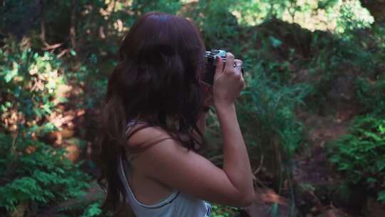 户外林中用相机拍照的女子