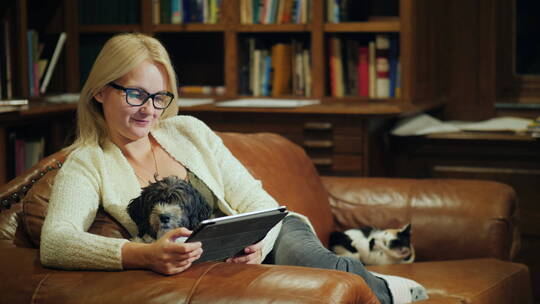沙发上小猫小狗和看书的女人