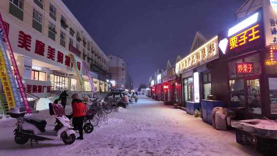 北方小城寒冬雪夜街景行人