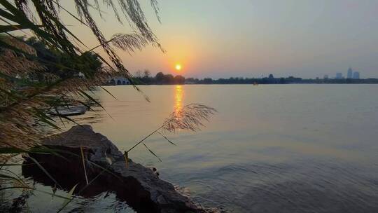 湖面的水波不兴，夕阳斜照