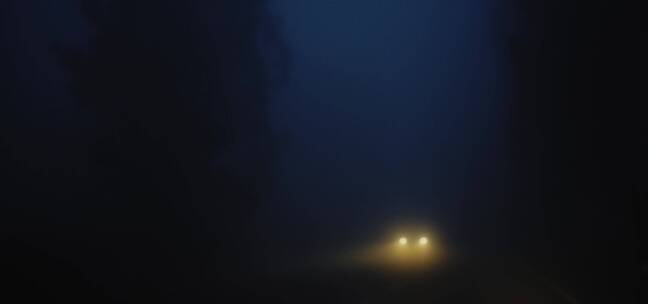汽车在大雾弥漫的马路上开着灯行驶