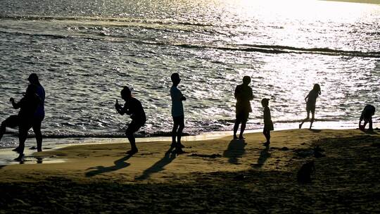 海南三亚黄昏阳光下沙滩度假的人群剪影视频素材模板下载