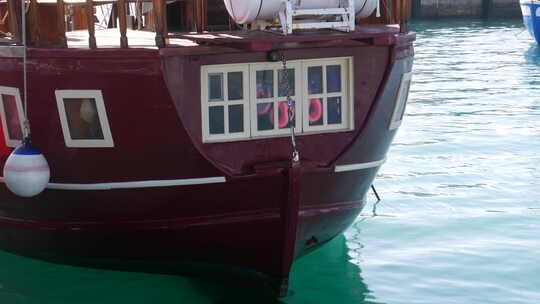 帆船船尾的特写镜头，古雅的窗户反映了船上