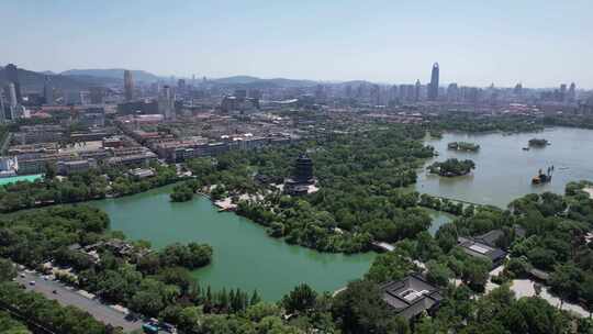 城市湖泊全景，周围环绕绿树与建筑