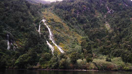 白天拍摄新西兰米尔福德湾峡湾的临时瀑布或瀑布范围。