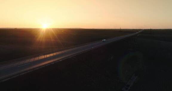 夕阳下在乡间公路上行驶的汽车